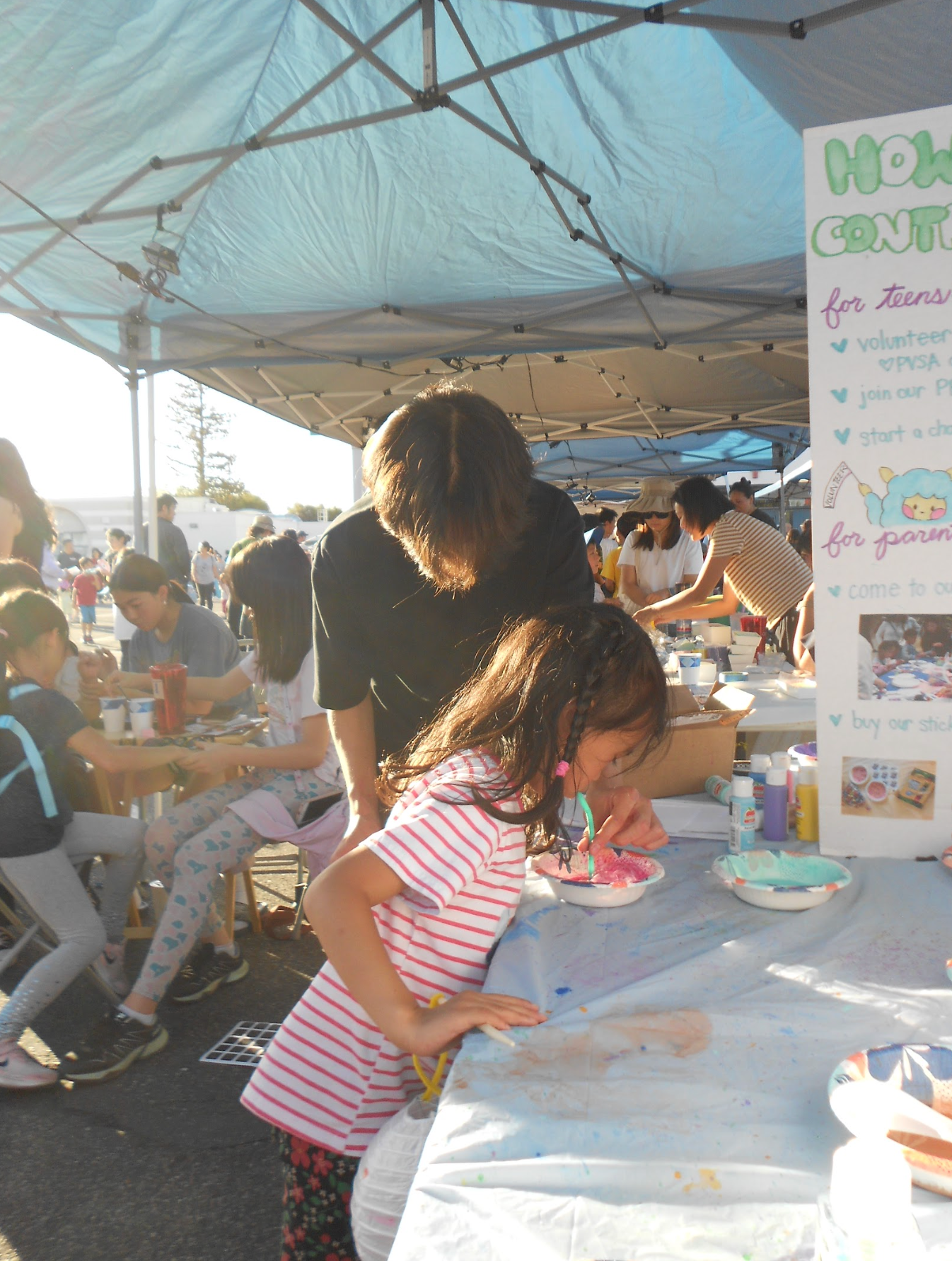 An Artify team member helping a girl blow a bubble