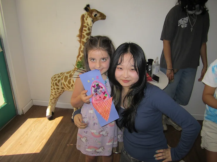 Katherine Yu (right) and Eve Herold (left) holding up the ice cream collage they made together